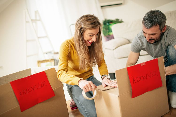 Un couple place des objets dans une boîte de don avant de déménager