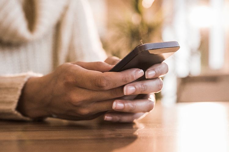 Close-up of a black cell phone in someone's hands