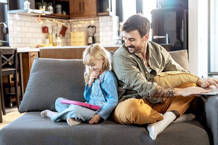 A father supervises his daughter's use of YouTube on a tablet