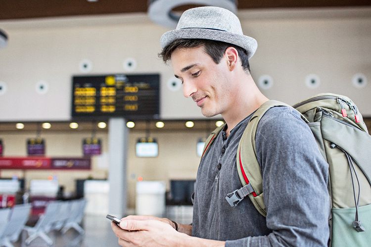 Traveller at the airport examining phone plans in Canada