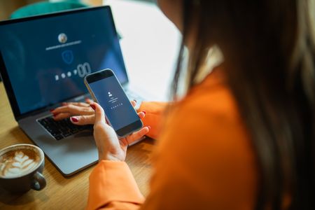 Femme se connectant à un compte en ligne à l’aide de l’authentification à double facteur.