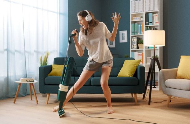 Personne qui chante en passant l'aspirateur dans son salon