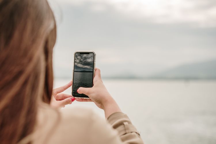 Une femme prend une photo avec un appareil mobile